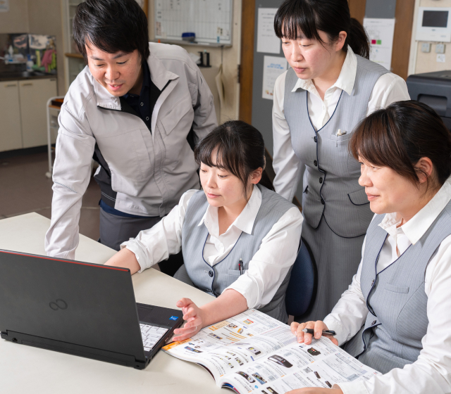 ノートPCを囲んで打ち合わせをするスタッフ